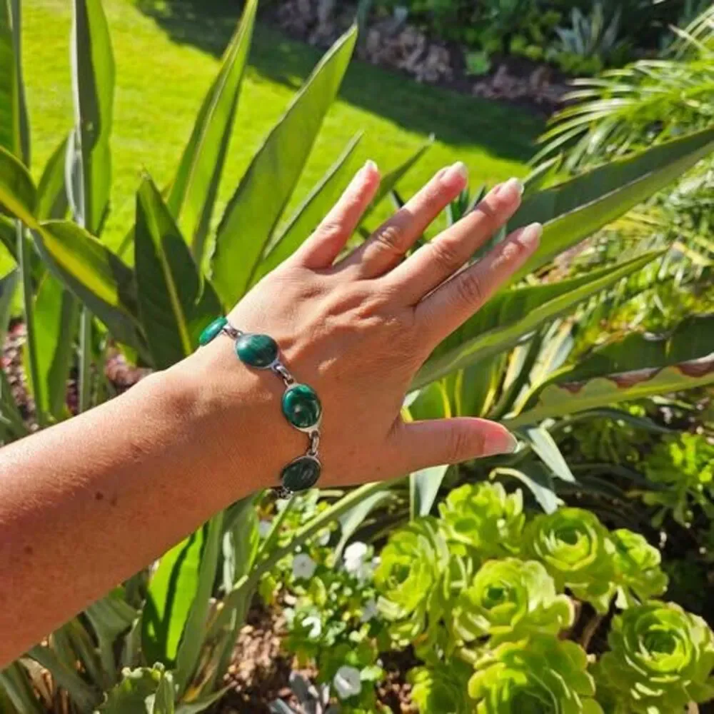 Malachite bracelet features natural green gemstones set in a silver colored link